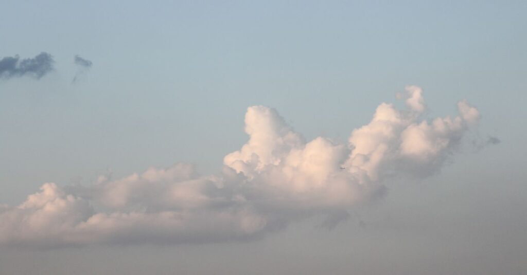 空に現れる龍神雲が光に包まれ、神秘的な龍の形をした雲のスピリチュアルな風景