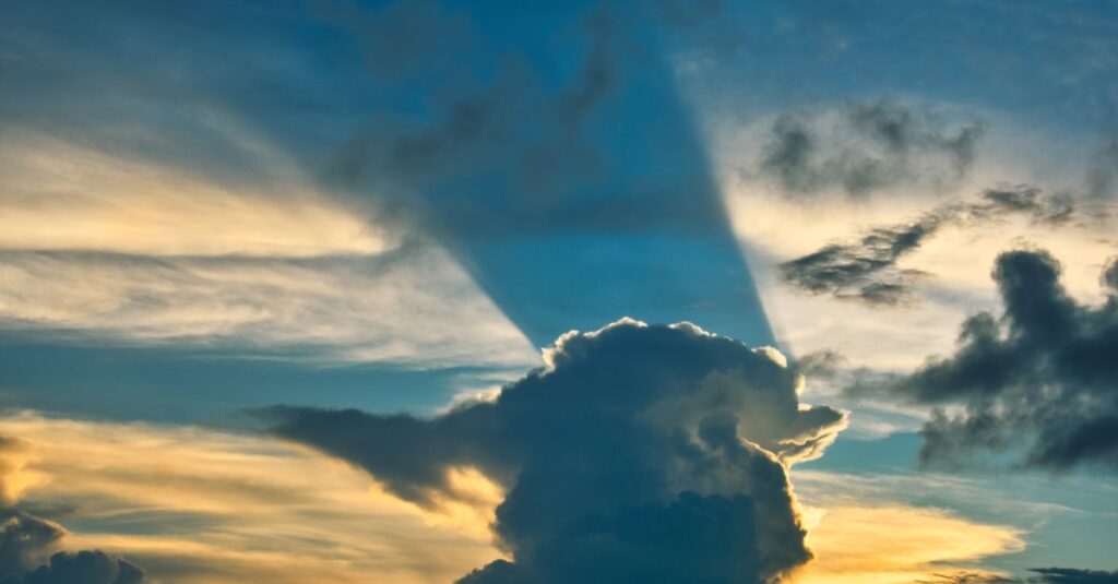 空に浮かぶ龍神雲を静かに撮影する人、光が雲を照らし神秘的に輝くスピリチュアルな風景